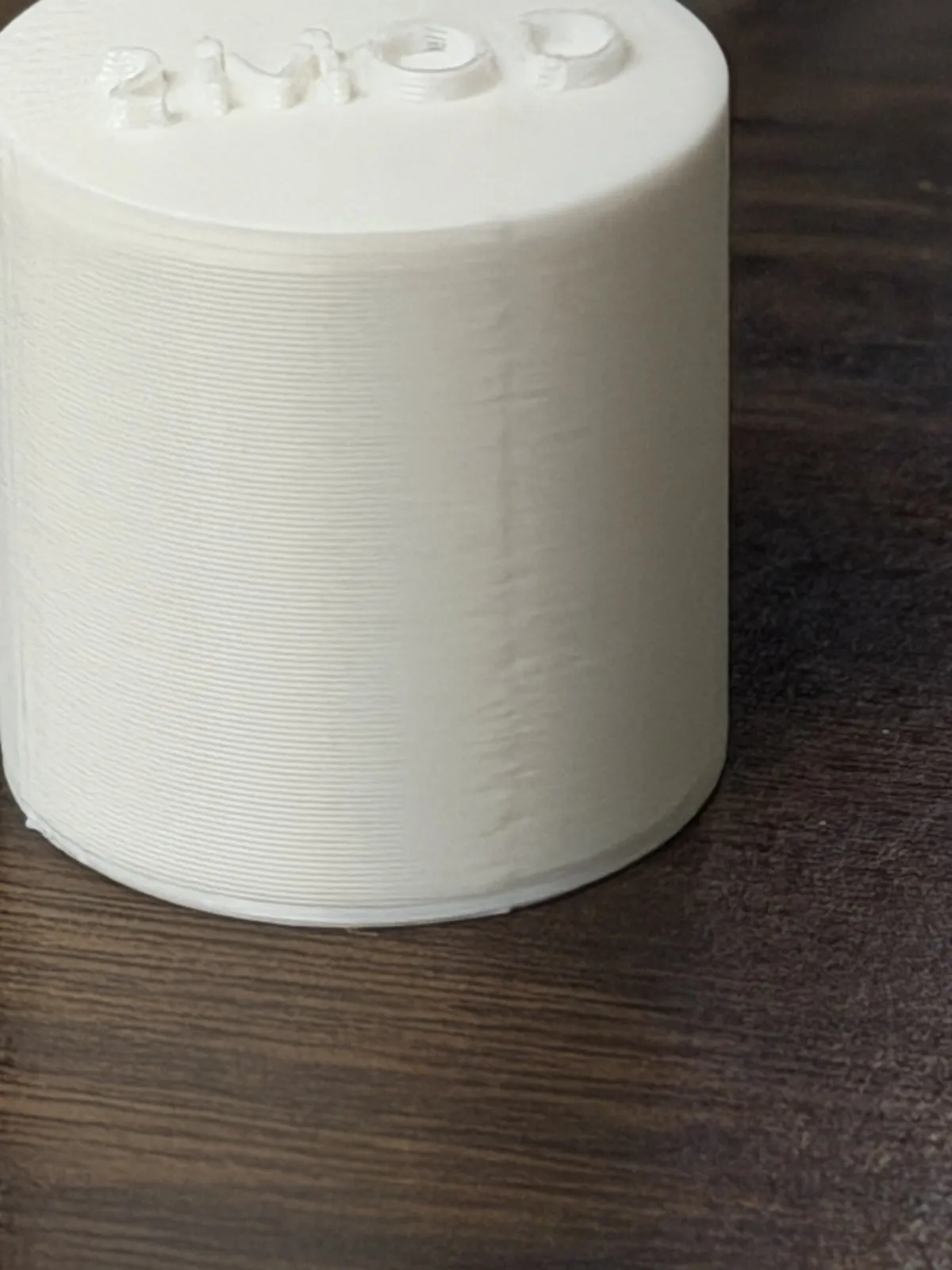 Close-up of a white PLA cylinder printed with the new settings, where the seam is only a faint band on the side