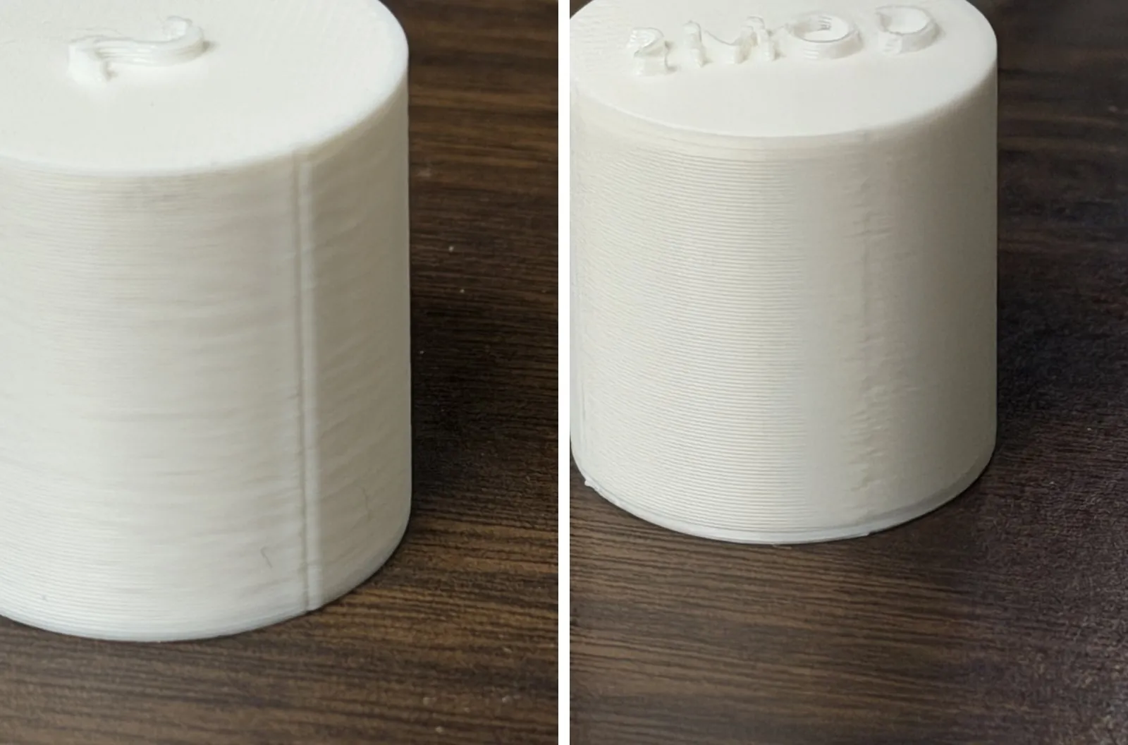 Two white PLA test cylinders side by side. The left one, printed with the stock profile, has a sharp raised seam line running top to bottom. The right one, printed with the new settings, shows only a faint band where the seam is.